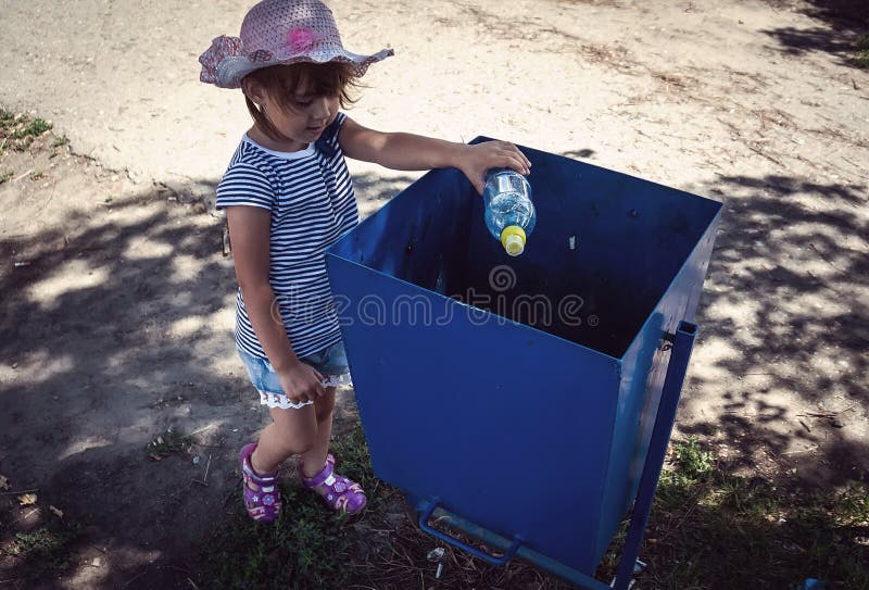 Menina para jogar afastado o lixo no lixo foto de stock Menina para jogar afastado o lixo no lixo foto de stock
