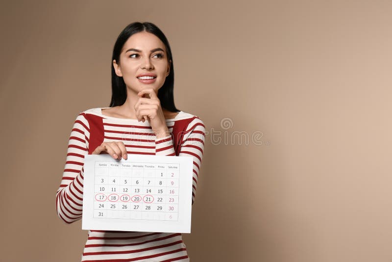 Menina penosa a segurar um calendário com dias de ciclo menstrual marcados em bege