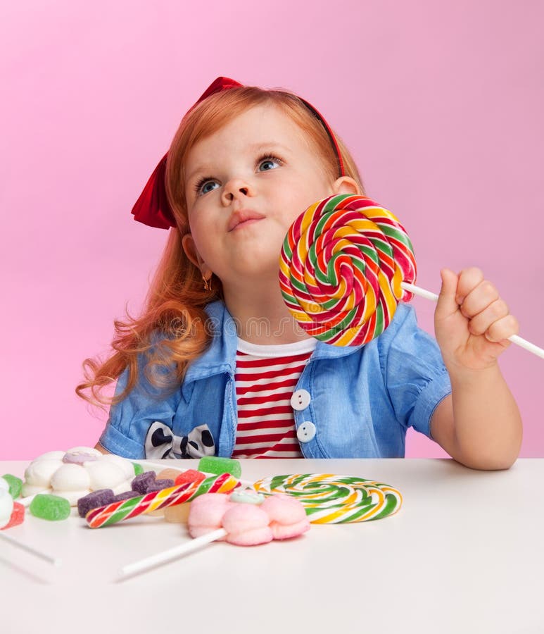 Menina pensativa com lollipop fotos de stock Menina pensativa com lollipop fotos de stock