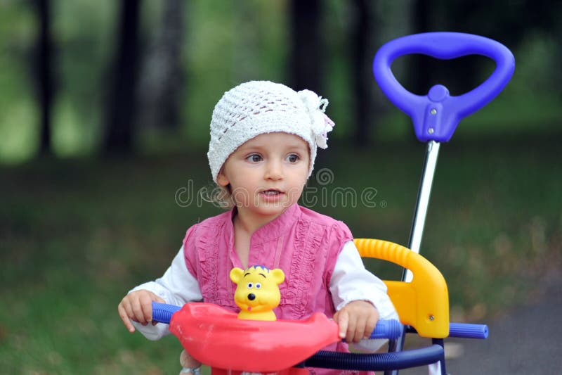 Menina pequena com triciclo imagem de stock royalty free Menina pequena com triciclo imagem de stock royalty free