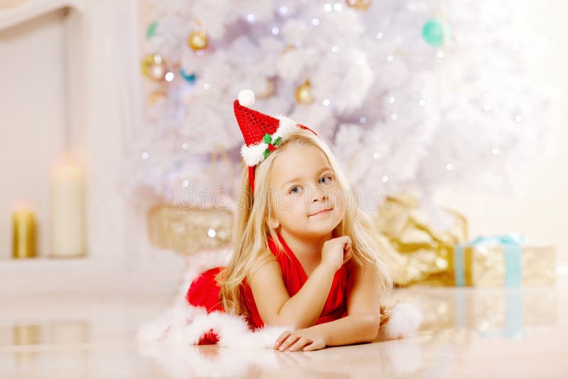 Menina pequena de Santa da beleza perto da árvore de Natal Wi felizes da menina