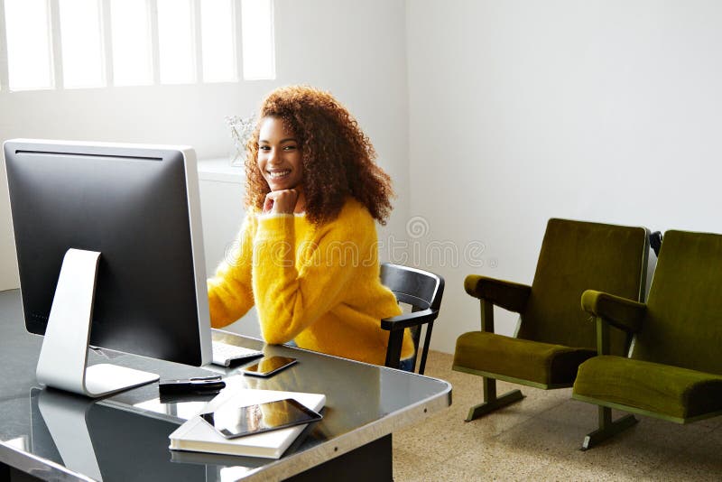 A menina preta bonita nova trabalha no escritório domiciliário fotografia de stock A menina preta bonita nova trabalha no escritório domiciliário fotografia de stock