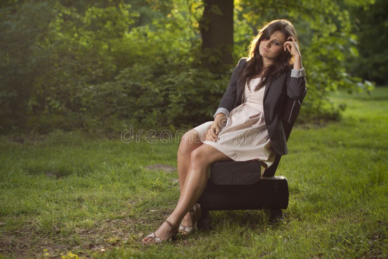 Menina profundamente nos pensamentos que sentam-se em um banco no parque imagem de stock royalty free Menina profundamente nos pensamentos que sentam-se em um banco no parque imagem de stock royalty free