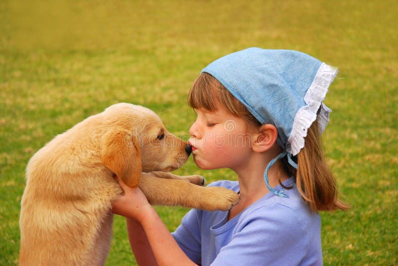 Menina que beija seu filhote de cachorro imagem de stock royalty free Menina que beija seu filhote de cachorro imagem de stock royalty free