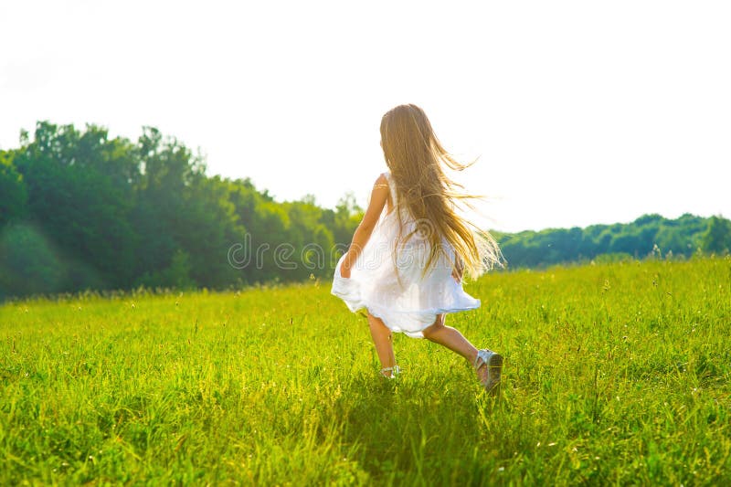 Menina que corre na grama verde imagem de stock royalty free Menina que corre na grama verde imagem de stock royalty free