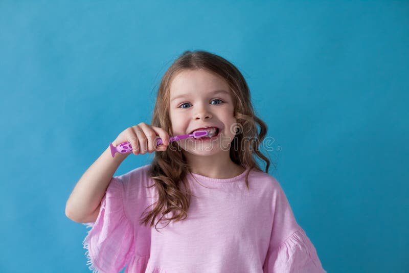 Menina que escova seus dentes com um dente da escova de dentes foto de stock Menina que escova seus dentes com um dente da escova de dentes foto de stock