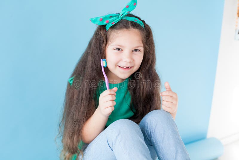Menina que escova seus dentes com um dente da odontologia da escova de dentes imagem de stock royalty free Menina que escova seus dentes com um dente da odontologia da escova de dentes imagem de stock royalty free