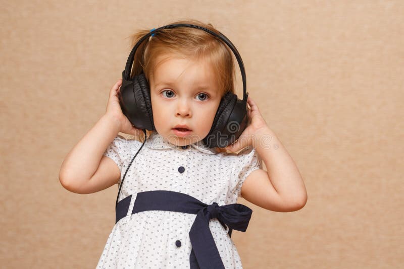 Menina que escuta a música em auscultadores foto de stock royalty free Menina que escuta a música em auscultadores foto de stock royalty free