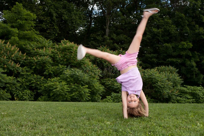 Menina que faz um cartwheel imagens de stock royalty free Menina que faz um cartwheel imagens de stock royalty free