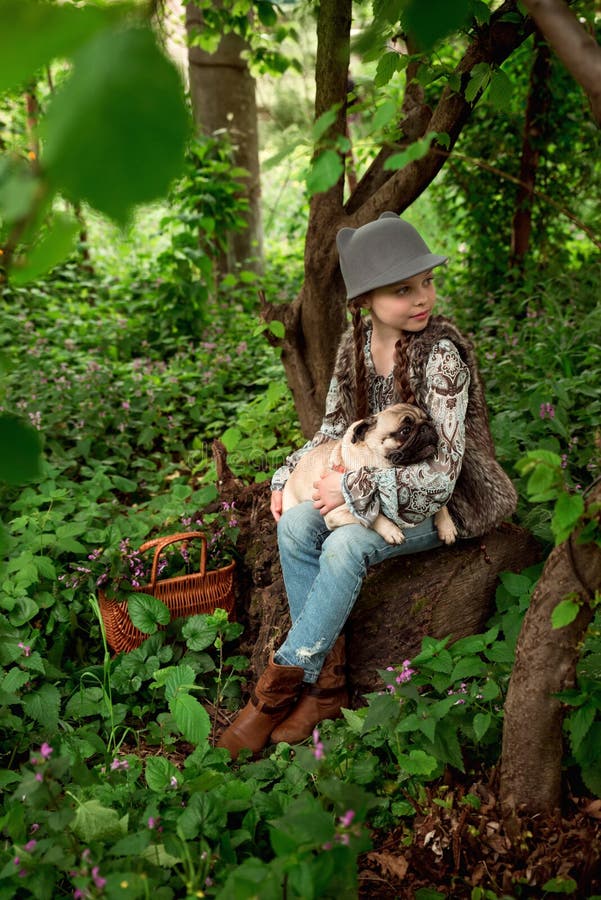 Little kid girl playing with her pug dog outdoors in rural areas in summer. Little kid girl playing with her pug dog outdoors in rural areas in summer.