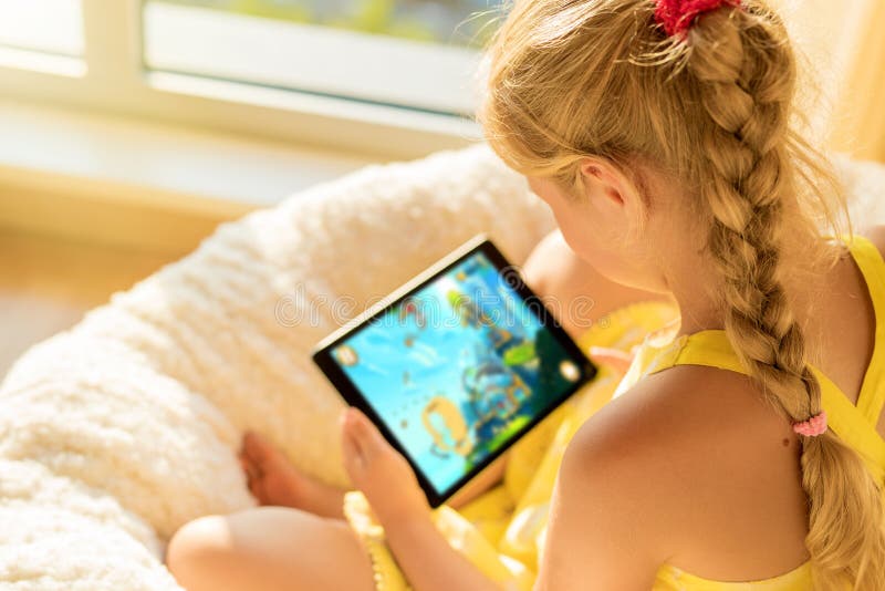 Menina Que Usa O Jogo Do Jogo Do Tablet Na Internet, Criança Que
