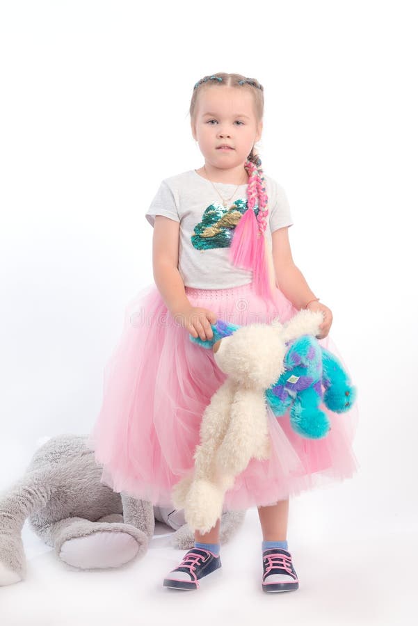 Menina que levanta junto com brinquedos grandes imagem de stock