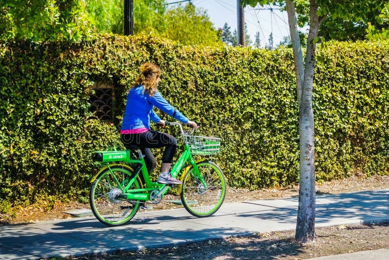 Menina que monta uma bicicleta do cal em um passeio foto de stock Menina que monta uma bicicleta do cal em um passeio foto de stock