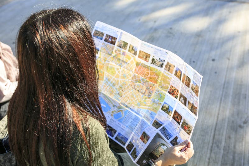 Menina que olha um mapa na rua imagens de stock royalty free Menina que olha um mapa na rua imagens de stock royalty free