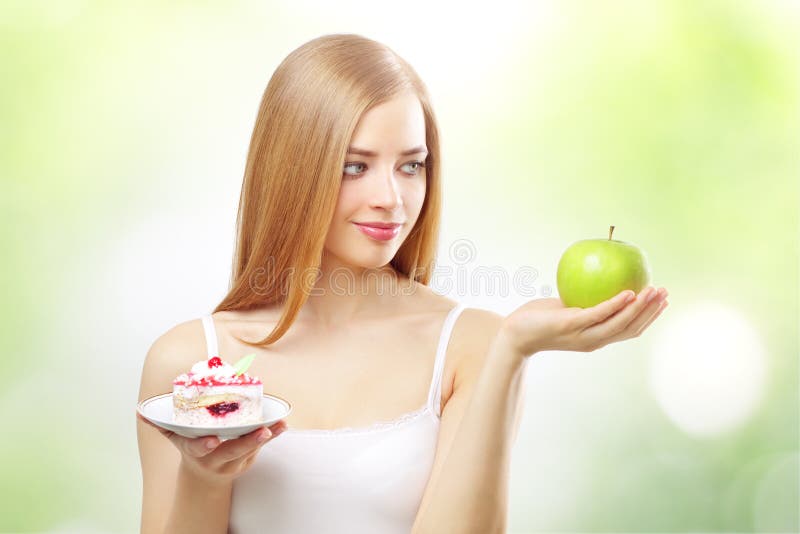 Menina que prende um bolo e uma maçã fotos de stock Menina que prende um bolo e uma maçã fotos de stock