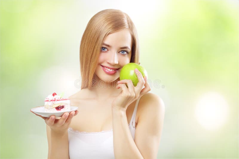 Menina que prende um bolo e uma maçã imagem de stock royalty free Menina que prende um bolo e uma maçã imagem de stock royalty free