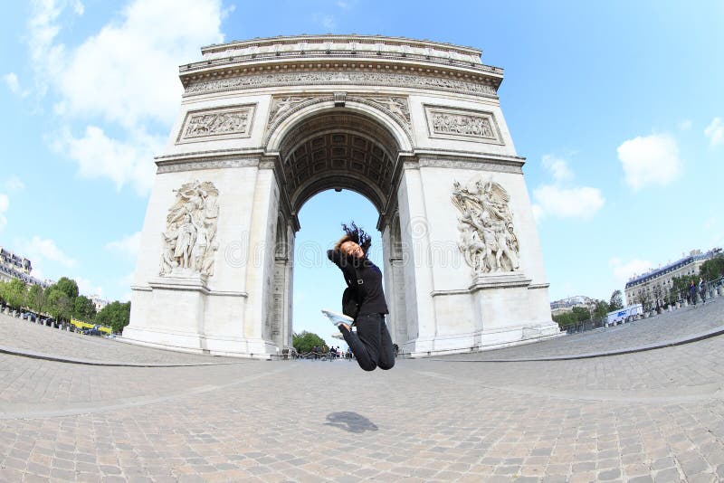 A menina que salta na frente de Arc de Triomphe fotografia de stock royalty free A menina que salta na frente de Arc de Triomphe fotografia de stock royalty free
