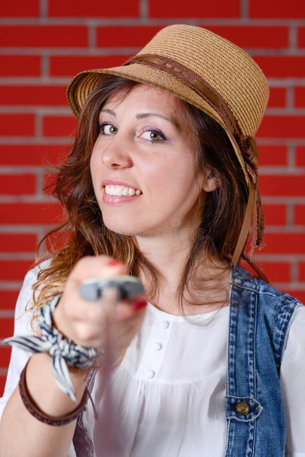 Menina que usa a vara do selfie na frente da parede de tijolo imagens de stock Menina que usa a vara do selfie na frente da parede de tijolo imagens de stock