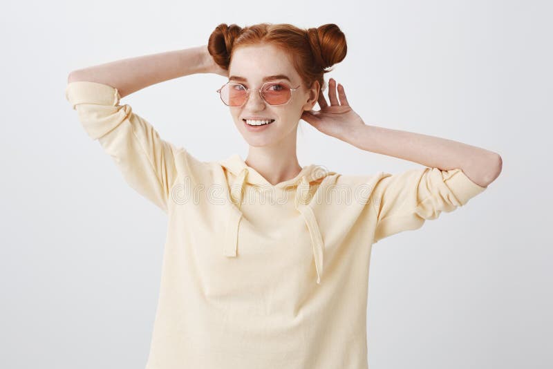 Menina que verifica o corte de cabelo, olhando no espelho O estúdio disparou do estudante fêmea novo à moda em óculos de sol eleg fotografia de stock Menina que verifica o corte de cabelo, olhando no espelho O estúdio disparou do estudante fêmea novo à moda em óculos de sol eleg fotografia de stock