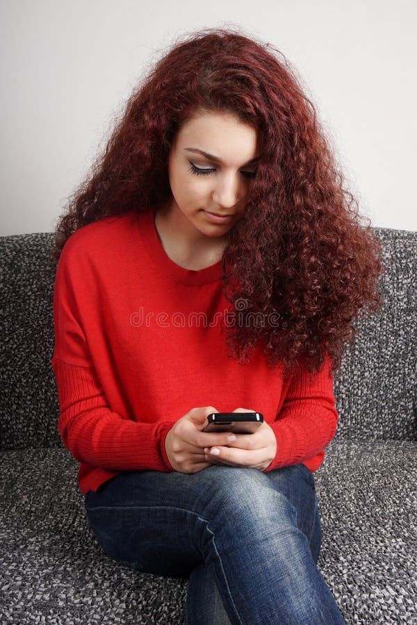 Menina que verifica seu smartphone fotografia de stock Menina que verifica seu smartphone fotografia de stock