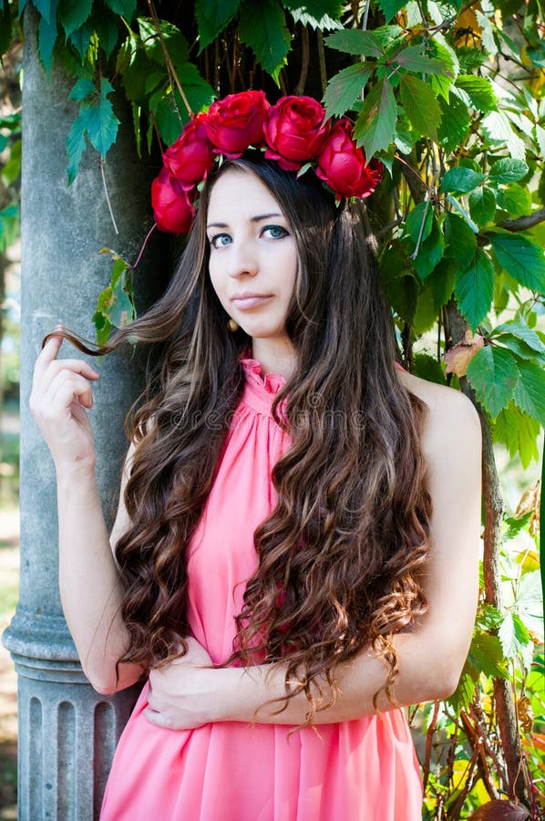 Menina que veste uma coroa das rosas imagem de stock royalty free Menina que veste uma coroa das rosas imagem de stock royalty free