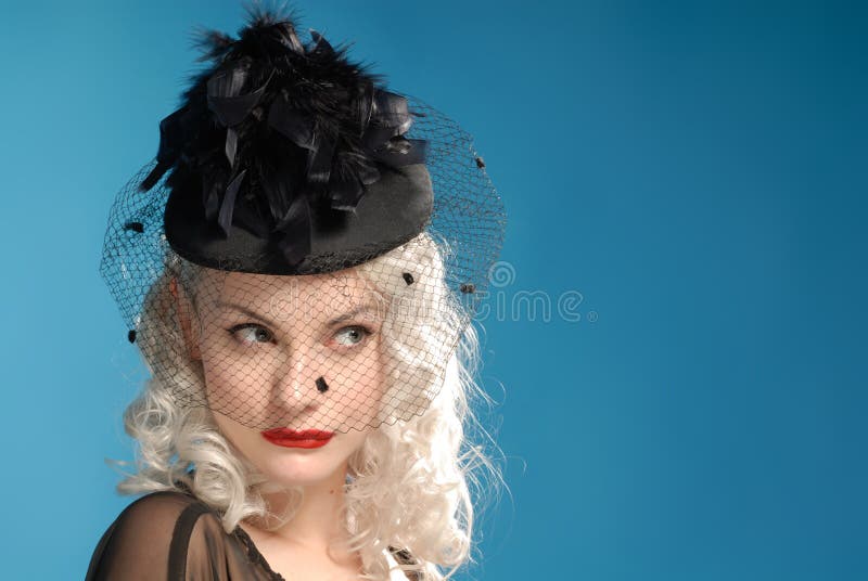 Menina retro lindo no chapéu dos anos quarenta com penas
