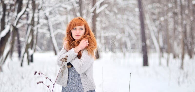 Menina ruivo bonita em uma floresta nevado