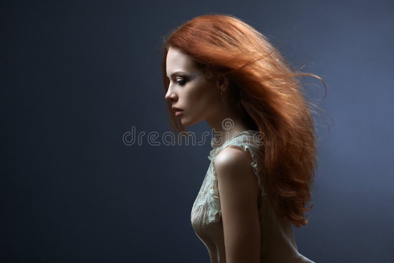 Menina ruivo bonita na obscuridade imagens de stock royalty free Menina ruivo bonita na obscuridade imagens de stock royalty free