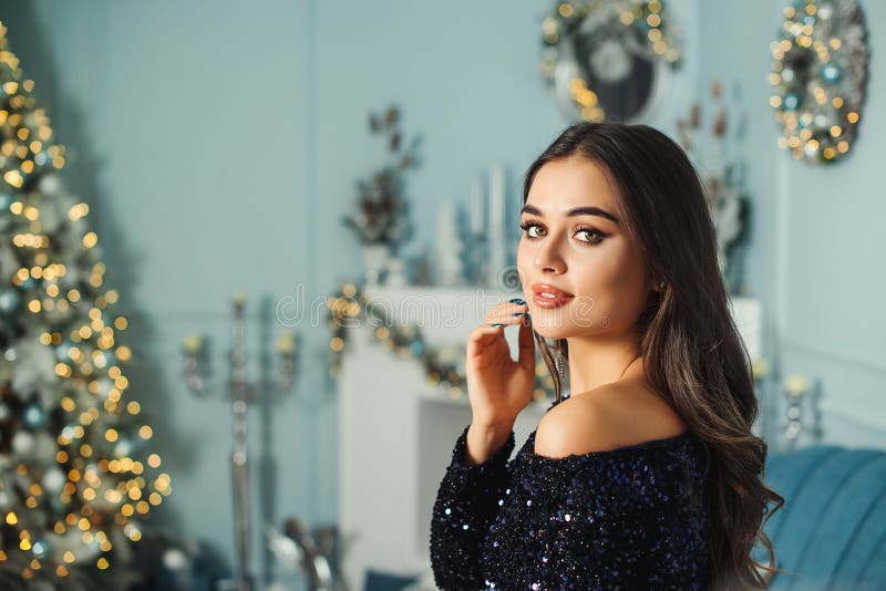 Menina sedutora com maquiagem de moda e penteado se posando no interior do natal de luxo Mulher vestida de moda com faíscas imagem de stock Menina sedutora com maquiagem de moda e penteado se posando no interior do natal de luxo Mulher vestida de moda com faíscas imagem de stock