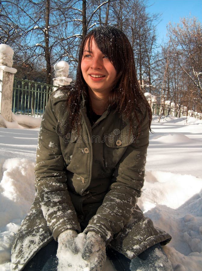 Download A Menina Senta-se Em Uma Neve Foto de Stock - Imagem de sorriso, emoções: 525586