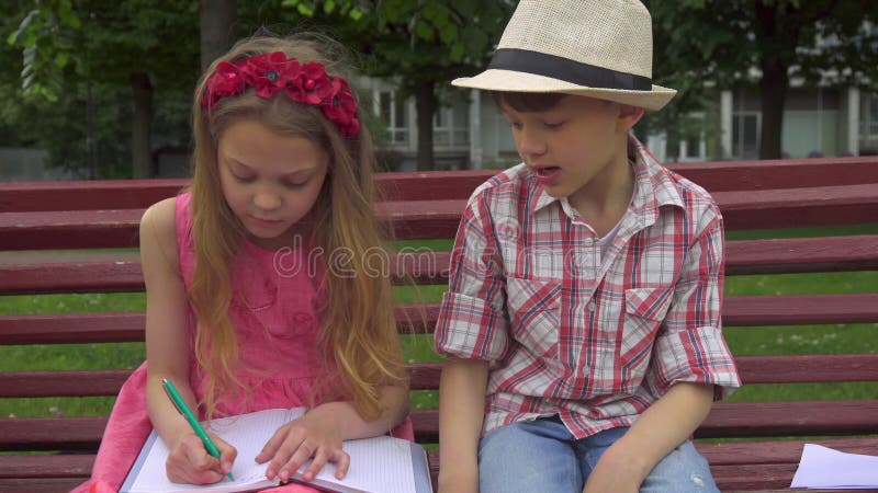 A menina tira no álbum no banco imagens de stock royalty free