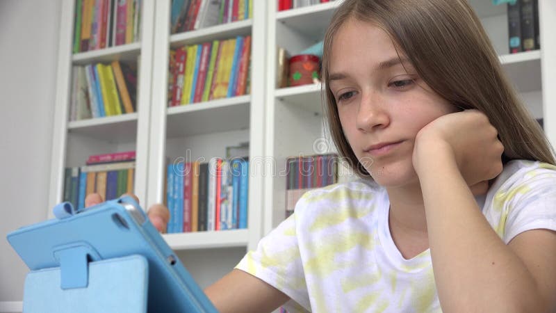 Menina Que Usa O Jogo Do Jogo Do Tablet Na Internet, Criança Que