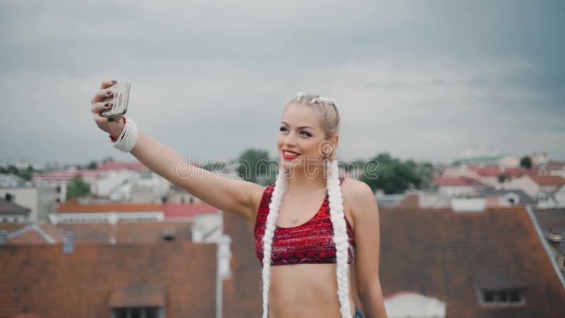 A menina toma selfies dsi mesma com smartphone