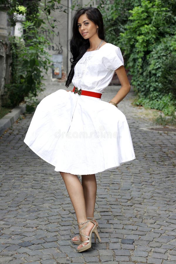 Menina triguenha agradável no vestido branco fotografia de stock royalty free Menina triguenha agradável no vestido branco fotografia de stock royalty free