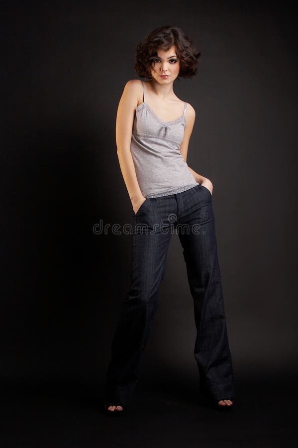 Menina triguenha que levanta no fundo escuro fotos de stock Menina triguenha que levanta no fundo escuro fotos de stock