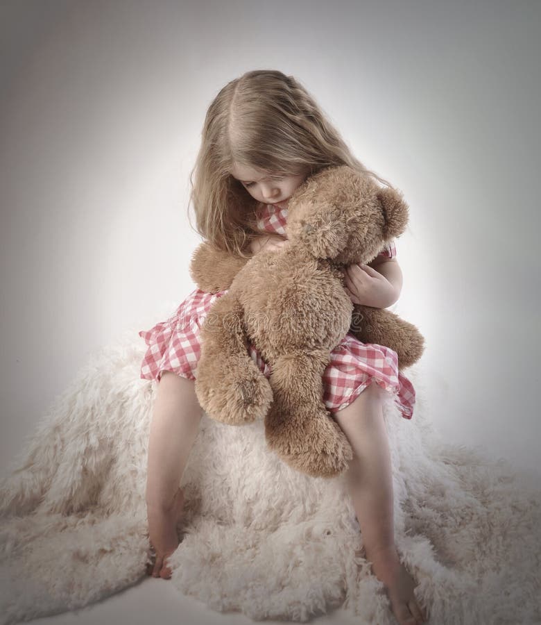 Menina triste que guarda Teddy Bear imagens de stock Menina triste que guarda Teddy Bear imagens de stock