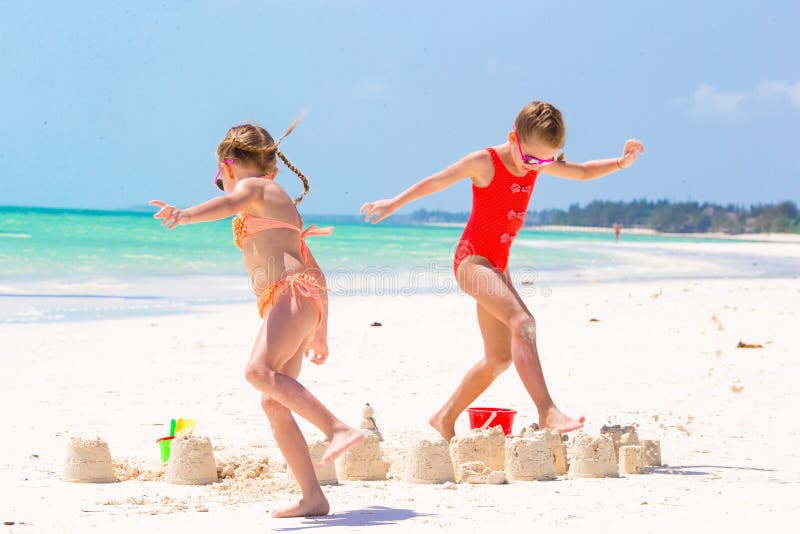 Meninas adoráveis durante férias de verão As crianças que jogam com praia brincam na praia branca imagens de stock Meninas adoráveis durante férias de verão As crianças que jogam com praia brincam na praia branca imagens de stock
