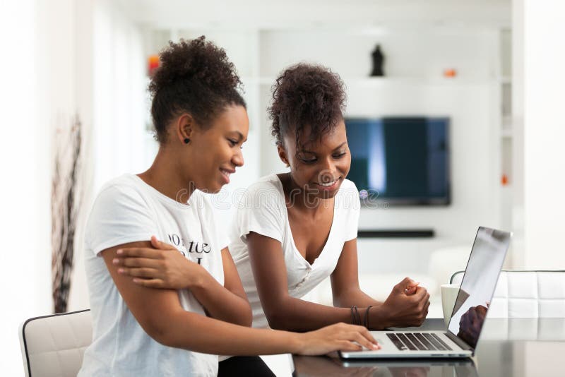 Meninas afro-americanos do estudante que usam um laptop - p preto