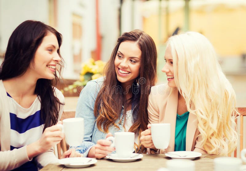 Meninas bonitas que bebem o café no café fotografia de stock royalty free Meninas bonitas que bebem o café no café fotografia de stock royalty free