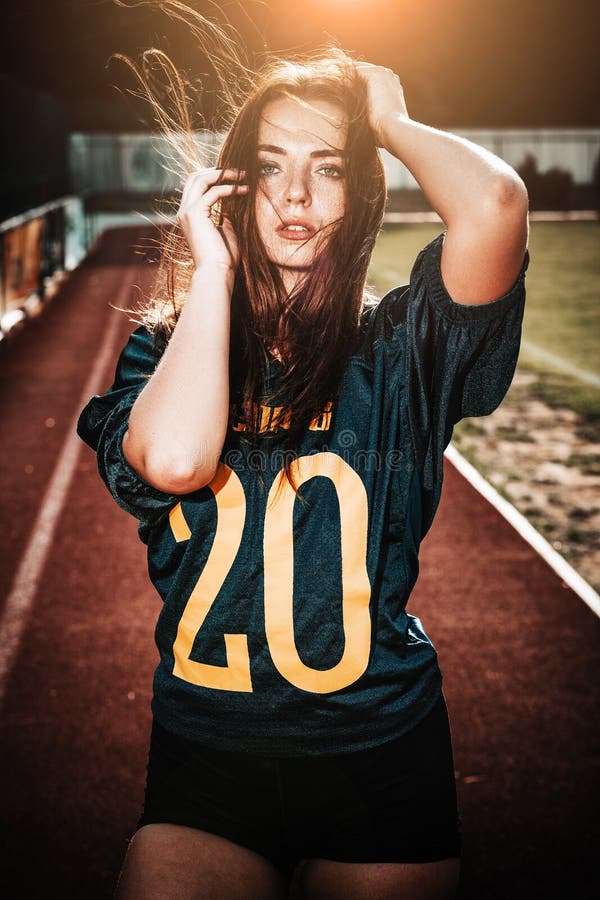 Meninas desportivos novas 'sexy' no t-shirt do jogador de futebol do rugby na ação no estádio Estada do jogador da mulher do fute foto de stock Meninas desportivos novas 'sexy' no t-shirt do jogador de futebol do rugby na ação no estádio Estada do jogador da mulher do fute foto de stock