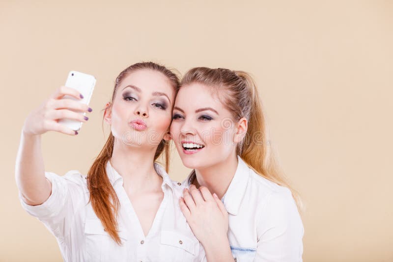 Meninas do estudante dos amigos que tomam a foto do auto com telefone esperto imagens de stock royalty free Meninas do estudante dos amigos que tomam a foto do auto com telefone esperto imagens de stock royalty free