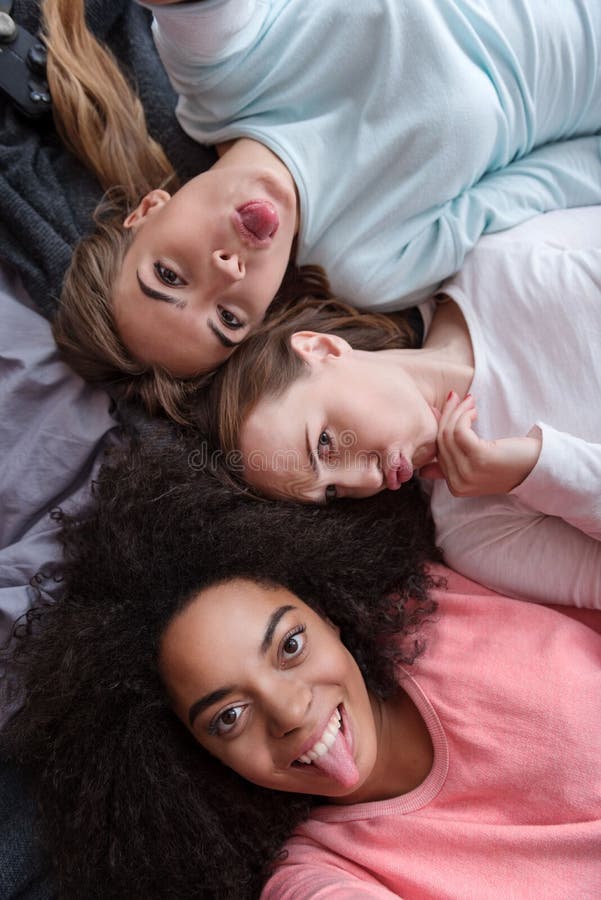 Meninas engraçadas que tomam o selfie e que jogam o macaco no quarto imagem de stock royalty free Meninas engraçadas que tomam o selfie e que jogam o macaco no quarto imagem de stock royalty free