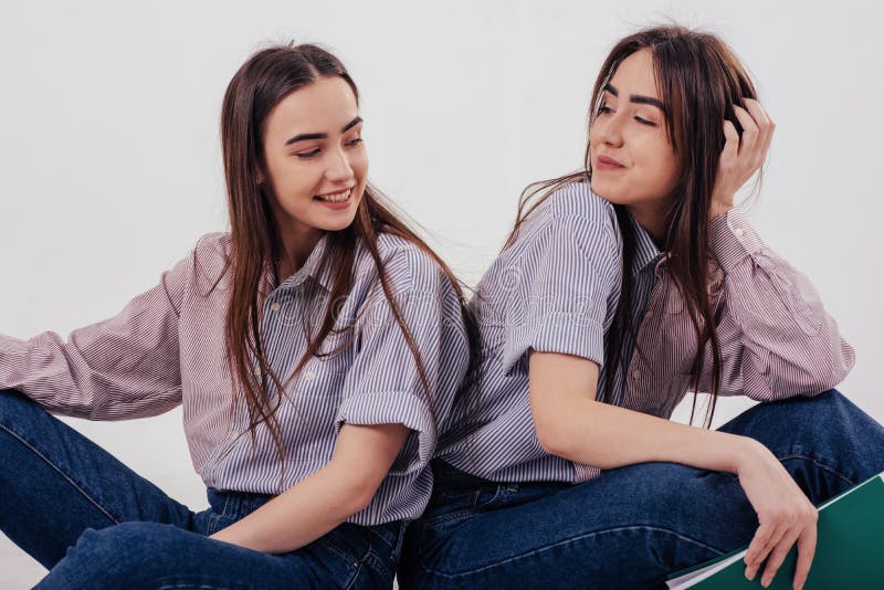 Meninas Lindas Duas Irmãs Gêmeas Sentadas E Posando No Estúdio Com Fundo  Branco Imagem de Stock - Imagem de profissional, humano: 165767723