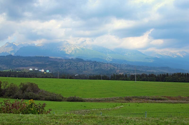 Mening van bergpieken en groene weide in de zomerlandschap van Tatra-Bergen, Slowakije royalty-vrije stock foto Mening van bergpieken en groene weide in de zomerlandschap van Tatra-Bergen, Slowakije royalty-vrije stock foto