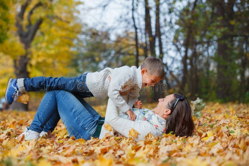 Menino adorável com sua mãe no parque do outono fotos de stock