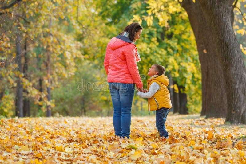 Menino adorável com sua mãe no parque do outono fotos de stock
