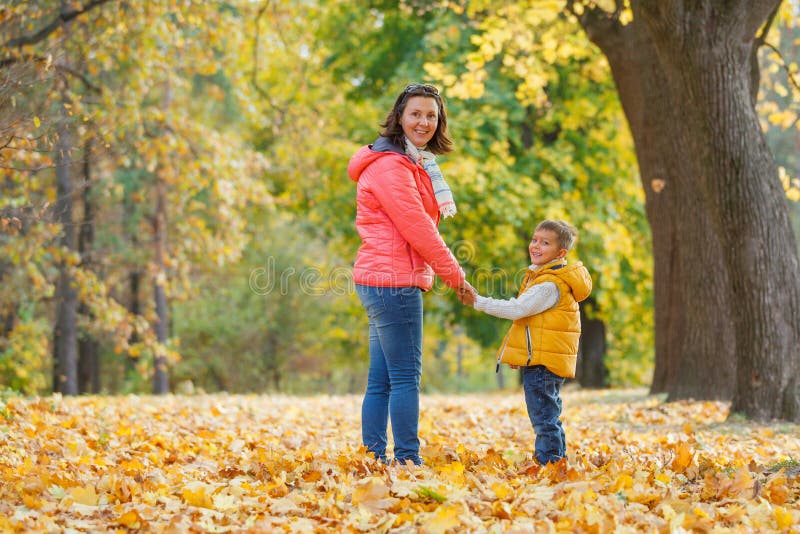 Menino adorável com sua mãe no parque do outono foto de stock royalty free