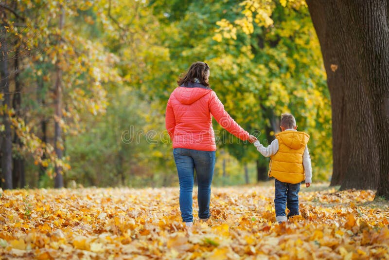 Menino adorável com sua mãe no parque do outono fotos de stock
