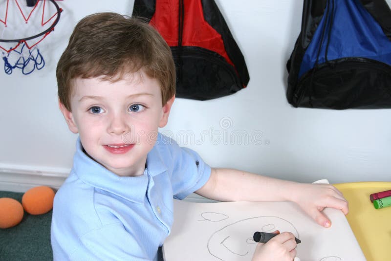 Menino adorável dos anos de idade quatro com os olhos azuis grandes que colorem em Presc fotos de stock Menino adorável dos anos de idade quatro com os olhos azuis grandes que colorem em Presc fotos de stock