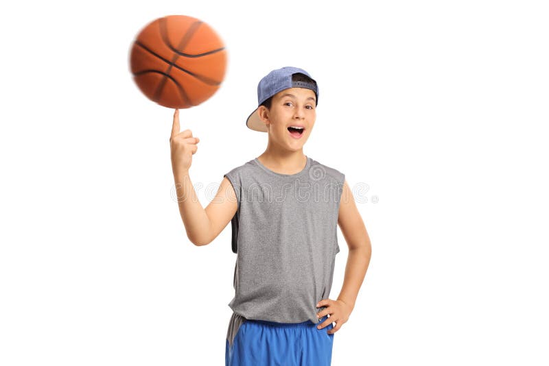 Menino alegre que gira um basquetebol em seu dedo